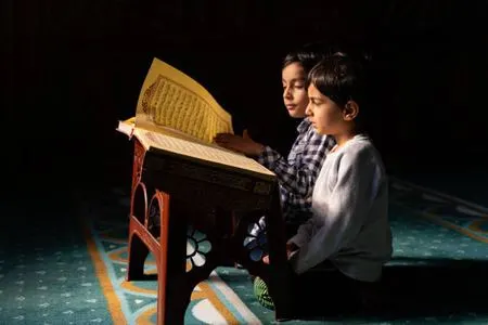 Two children reading Quran together with devotion